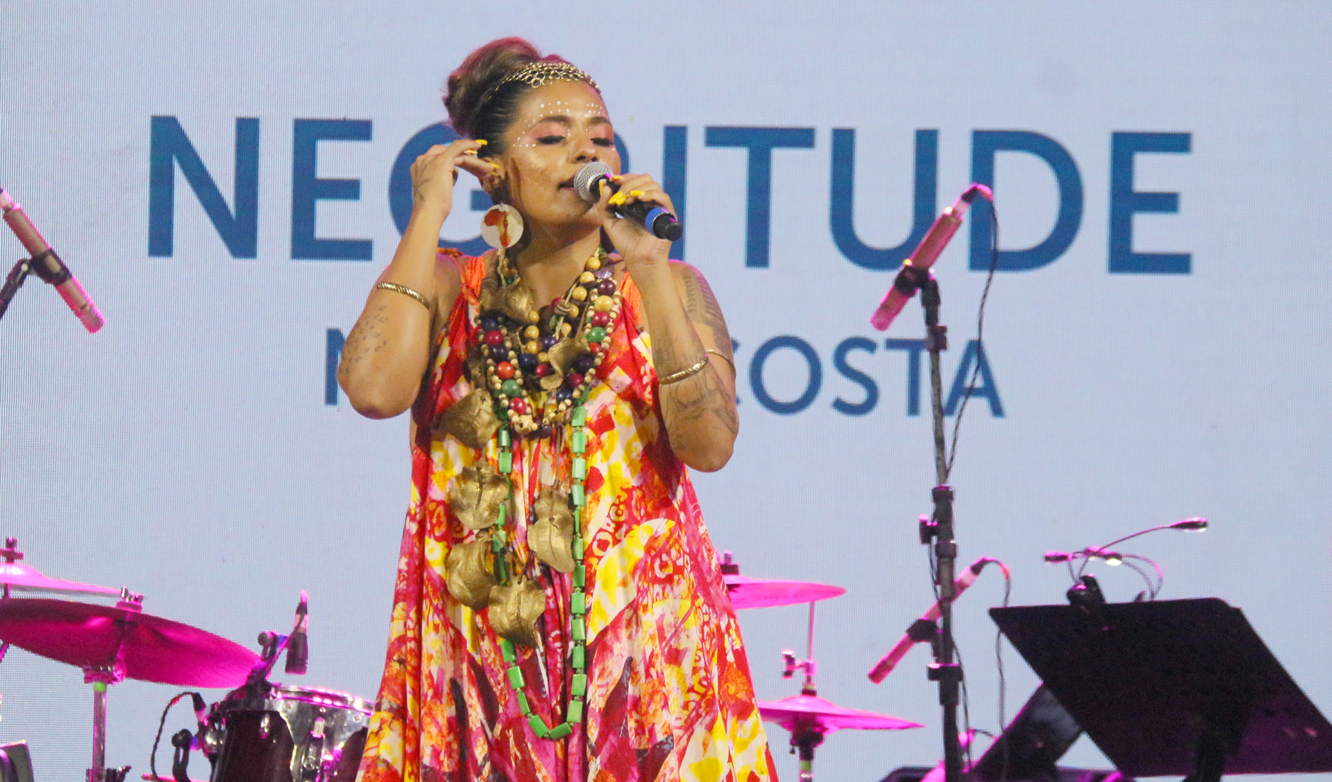Nayra Costa cantando ao microfone